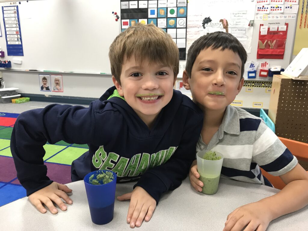 Two kids enjoying green smoothie