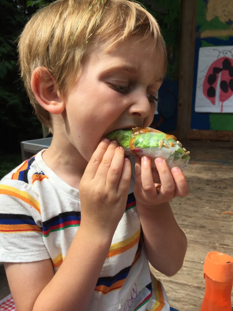 Child takes bite of spring roll