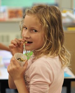 Girl enjoying eating a tasting of kale salad