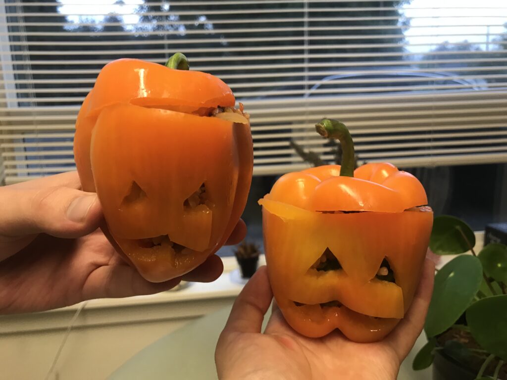 Two jack o lantern stuffed bell peppers