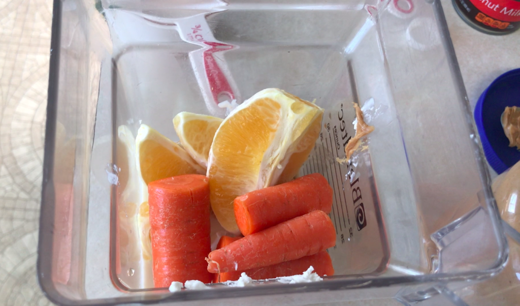 Orange and carrot in blender ready to make a smoothie