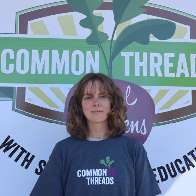 Sonya Hoffman stands in front of the Common Threads logo.