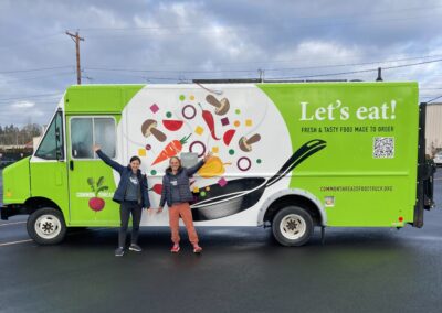 Executive Director Laura and Cooking Program Manager Carly standing in front of the food truck.