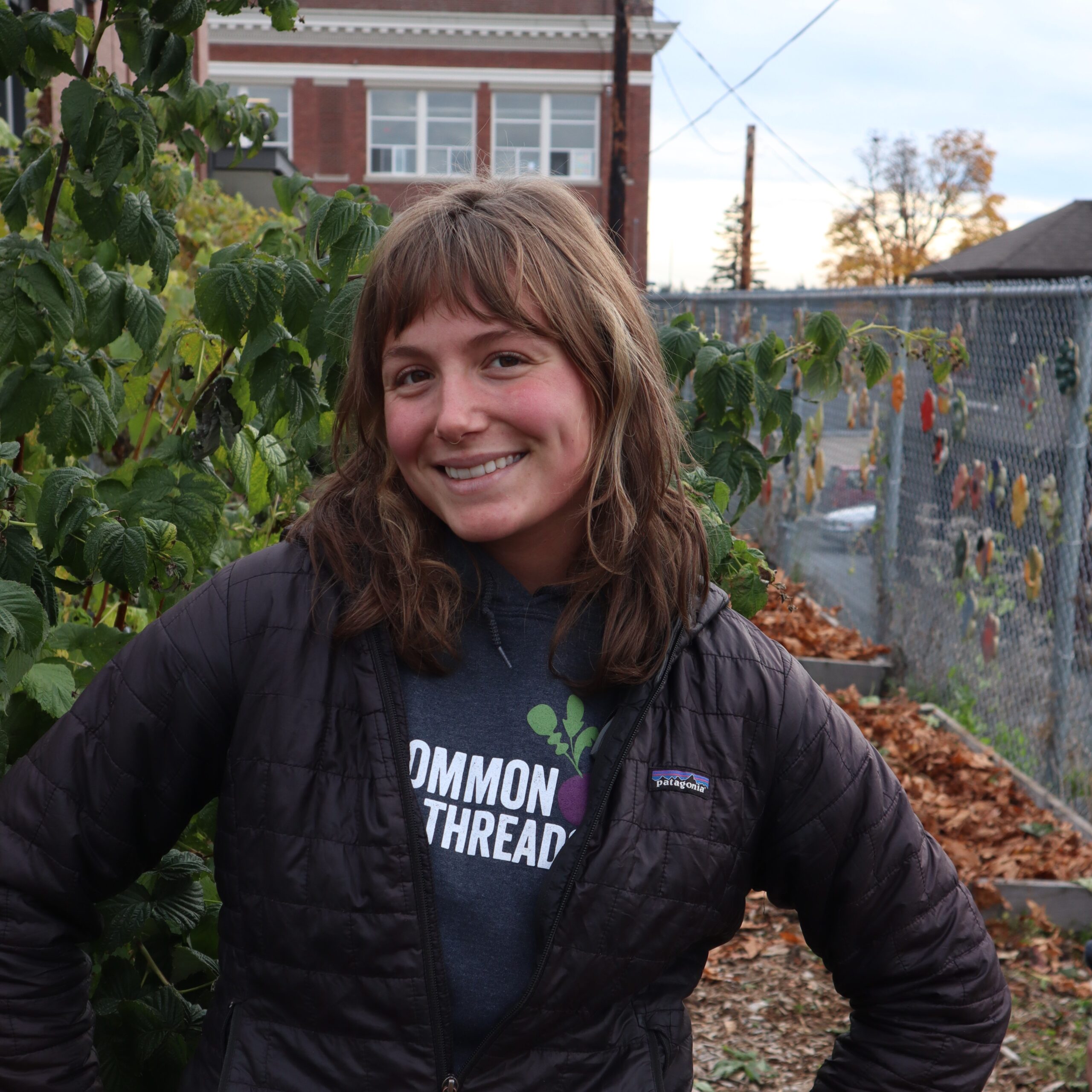 Melissa Rijkers stands in front of the Common Threads logo.