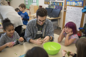 Common Threads Volunteer Daniel Murphy assisting with a cooking lesson